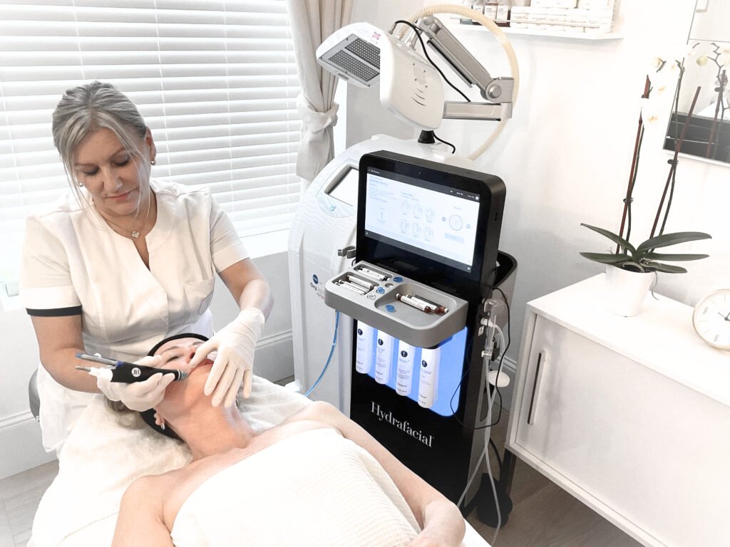 Esthetician is doing facial with a facial machine at a lying client on a bed